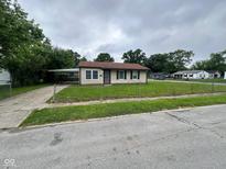 Charming single-story home with a chain-link fence and a convenient carport at 3302 N Butler Ave, Indianapolis, IN 46218
