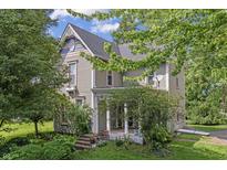 Charming two-story home featuring a beautiful front porch and mature trees, perfect for relaxed outdoor living at 38 W Main St, Brownsburg, IN 46112