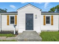 Charming home featuring a decorative security door, white siding, and wood shutters at 452 N Fenton Ave, Indianapolis, IN 46219