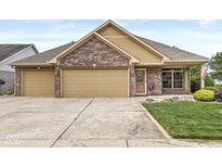 Charming brick home featuring a two-car garage, manicured lawn, and inviting curb appeal at 5659 Augusta Woods Dr, Plainfield, IN 46168