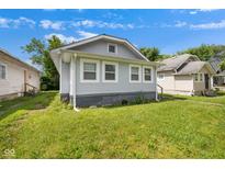 Charming home with a light gray exterior and a well-maintained lawn at 615 Udell St, Indianapolis, IN 46208