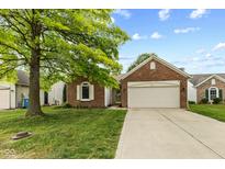 Charming single-story brick home with a well-manicured lawn and a two-car attached garage at 619 Cahill Ln, Indianapolis, IN 46214