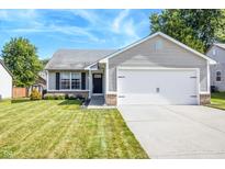 Charming single-story home featuring a two-car garage and well-manicured front lawn on a sunny day at 740 Springmill Dr, Mooresville, IN 46158