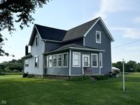 Charming two-story home with blue siding, black roof, and a well-maintained lawn at 9721 S 100 E, Pendleton, IN 46064