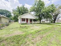 Charming single-story home with red accents, a cozy porch, and a partially fenced yard at 1002 S Fleming St, Indianapolis, IN 46241