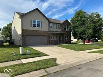 Two-story home featuring a brick and siding facade, an attached two-car garage, and a well-manicured lawn at 11154 Schoolhouse Rd, Fishers, IN 46037