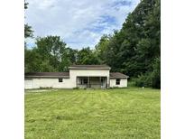 Charming two-story home with a covered porch and spacious front yard surrounded by mature trees at 1330 Schleicher Ave, Indianapolis, IN 46229