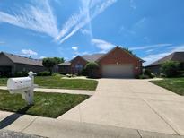 Charming brick home with a well-manicured lawn and a two-car garage at 1633 Belfield St, Indianapolis, IN 46217