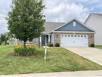 Charming single-story home featuring a two-car garage, well-manicured lawn and beautiful landscaping at 1706 Creekwater Pass, Greenfield, IN 46140