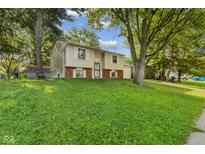 Charming split-level home with well-maintained lawn and mature trees at 1809 Mutz Dr, Indianapolis, IN 46229
