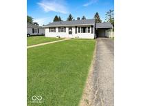 Charming single-story home with a well-maintained lawn, attached carport, and classic black shutters at 205 Eikenberry St, Greenfield, IN 46140