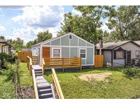 Charming home featuring light-blue siding, wood accents, wooden porch and new front steps at 2724 N Dearborn St, Indianapolis, IN 46218