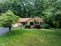Charming stone-clad home with lush lawn, mature trees, and inviting landscaping creates a welcoming exterior at 3813 N Ramsgate Rd, Martinsville, IN 46151