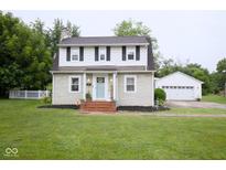 Charming two-story home with manicured lawn, brick walkway, and detached two car garage at 643 Harlan St, Plainfield, IN 46168