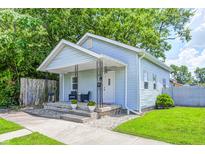 Charming blue home with a covered front porch, wrought iron posts, and tidy landscaping at 725 2Nd St, Shelbyville, IN 46176