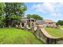 Stunning brick home featuring a curved brick retaining wall and beautiful landscaping at 7843 E Triple Crown Ln, Camby, IN 46113