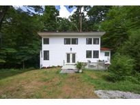 Charming two-story home with a white exterior, front deck, and surrounded by lush trees at 8167 Center Lake Rd, Nineveh, IN 46164
