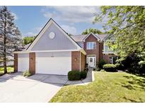 Charming two-story brick home boasts a well-manicured lawn, three car garage, and lovely curb appeal at 8909 Carnation Dr, Noblesville, IN 46060