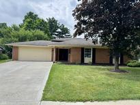 Charming one-story brick home with a well-maintained lawn and concrete driveway at 9621 Gemini Dr, Indianapolis, IN 46229