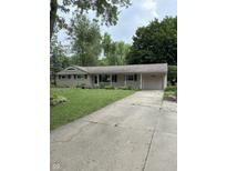 Charming single-story home with an attached garage and a well-manicured lawn at 10155 Orchard Park W Dr, Carmel, IN 46280