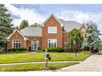 Charming brick home with manicured lawn, a welcoming entrance, and beautiful trees at 14030 Old Mill Ct, Carmel, IN 46032
