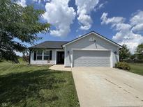 Charming single-story home with a well-manicured lawn and attached two-car garage at 1406 Bigleaf Cir, Sheridan, IN 46069