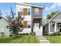 Striking two-story home boasting a modern facade, manicured lawn, and inviting front steps at 1406 Linden St, Indianapolis, IN 46203
