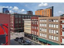 Charming exterior view of historic downtown buildings with blue sky and clouds at 207 S Meridian St # 2F, Indianapolis, IN 46225