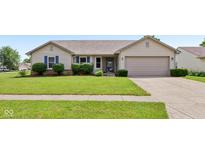 Charming single-story home featuring blue shutters, well-manicured lawn, and an attached two car garage at 2127 Yosemite Dr, Lebanon, IN 46052