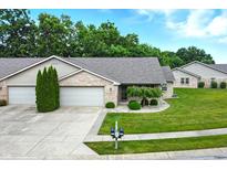 Charming brick home with well-manicured lawn, mature trees, and a two-car garage at 3920 Oak Harbor Ln, Indianapolis, IN 46237
