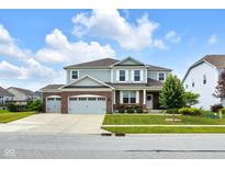 Charming two-story home features a three-car garage and professionally landscaped front yard at 6137 Hardwick Dr, Whitestown, IN 46075