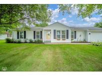 Charming single-story home featuring a well-manicured lawn, flower boxes, and bright yellow door at 124 Bess Blvd, Pendleton, IN 46064