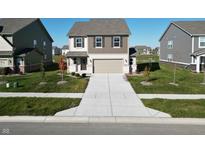 Inviting two-story home featuring a two-car garage, well-manicured lawn, and a long, spacious driveway at 1248 Cassine Pl, Greenwood, IN 46143