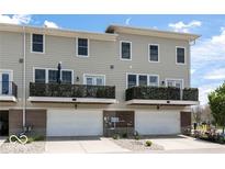 Modern townhome exterior with balconies, two-car garage and neutral siding at 12838 Bird Cage, Carmel, IN 46032