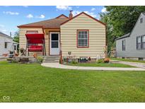 Charming bungalow with a well-maintained lawn, sidewalk and a welcoming front porch swing at 2017 E Legrande Ave, Indianapolis, IN 46203
