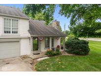 Charming two-story home features a covered front porch, stone chimney, and well-maintained landscaping at 2578 Chaseway Ct, Indianapolis, IN 46268