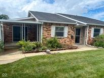 Charming brick townhome featuring a covered front porch and a well-maintained lawn at 2770 Two Worlds Dr, Columbus, IN 47201