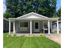 Charming home with a covered front porch, a swing, well-manicured lawn, and appealing curb appeal at 2822 Tindall St, Indianapolis, IN 46203