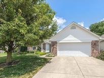 Traditional home with a two-car garage, brick accents, and mature landscaping at 6928 Shoals Way, Indianapolis, IN 46237