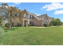 Charming brick home with manicured lawn and landscaping under a sunny blue sky at 7830 Cross Creek, Avon, IN 46123