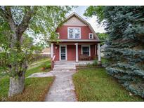 Charming two-story home with a welcoming front porch and well-maintained lawn and lovely mature trees at 11218 Exchange St, Indianapolis, IN 46259