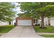 Charming single-Gathering home featuring a brick facade, a two-car garage, and mature trees enhancing curb appeal at 11620 Glenn Abbey Ln, Indianapolis, IN 46235
