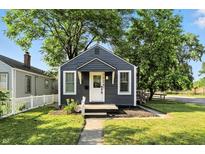 Charming single-story home with blue siding, white trim, landscaped yard, and a sidewalk leading to the front door at 1324 E 9Th, Indianapolis, IN 46202
