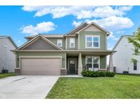 Charming two-story home featuring a well-manicured lawn and attached two-car garage, with a quaint front porch at 1460 Boots Trl, Greenfield, IN 46140