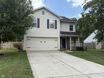 Two-story home with white siding, shutters, attached two-car garage, concrete driveway, and small front porch at 187 Broadmoor Bnd, Pittsboro, IN 46167
