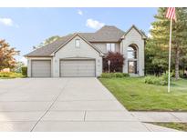 Beautiful two-story brick home with a three-car garage and well-manicured lawn on a sunny day at 2320 Whispering Way, Indianapolis, IN 46239