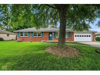 Charming brick ranch-style home with blue shutters, two-car garage, and mature trees at 3504 White River Ct, Anderson, IN 46012