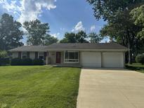 Charming ranch-style home featuring a well-manicured lawn, red shutters, and an attached two-car garage at 4032 Roselawn Ave, Columbus, IN 47203