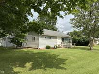 Charming single-story home with a lush lawn, a small front porch, and mature trees providing shade at 411 N 18Th St, Noblesville, IN 46060