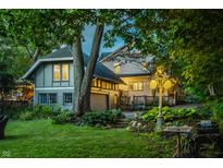 Charming two-story home with landscaped yard and lush green lawn at dusk at 4130 N Meridian St, Indianapolis, IN 46208